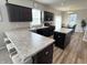 A kitchen with dark cabinets, granite countertops, an island, and barstool seating offers style and function at 4245 W Fork Dr, Westfield, IN 46062
