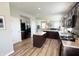 A well-lit kitchen with dark cabinets, granite countertops, stainless steel refrigerator and an island at 4245 W Fork Dr, Westfield, IN 46062