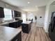 A kitchen with dark cabinets, granite countertops, an island with barstool seating, and wood-look flooring at 4245 W Fork Dr, Westfield, IN 46062