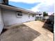 A view of the concrete patio of a light colored house with a grassy backyard with a storage building at 4335 River Rd, Columbus, IN 47203