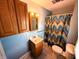 Bathroom featuring blue walls, wood vanity, mirror and shower with colorful curtain at 4335 River Rd, Columbus, IN 47203