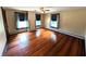 A spacious bedroom with hardwood floors, three windows and neutral wall colors at 4335 River Rd, Columbus, IN 47203