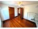 Bedroom featuring hardwood floors, a ceiling fan, and multiple doors and a closet at 4335 River Rd, Columbus, IN 47203