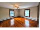 Bedroom with hardwood floors, ceiling fan, and two large windows offering plenty of natural light at 4335 River Rd, Columbus, IN 47203