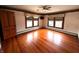Bright bedroom featuring hardwood floors, a ceiling fan, and two windows dressed with valances at 4335 River Rd, Columbus, IN 47203