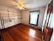 Bedroom featuring hardwood floors, a ceiling fan, storage shelving and a large window at 4335 River Rd, Columbus, IN 47203