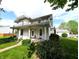 Charming two-story home with a covered front porch and landscaped yard, perfect for relaxation at 4335 River Rd, Columbus, IN 47203