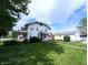 Charming two-story house with a cozy front porch, lush greenery, and a detached garage, perfect for outdoor enjoyment at 4335 River Rd, Columbus, IN 47203