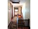 Hallway with hardwood floors, an area rug, stairs with a safety gate, and plenty of natural light at 4335 River Rd, Columbus, IN 47203