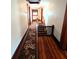 Long hallway with hardwood floors, a floral rug, and stairs with a safety gate at 4335 River Rd, Columbus, IN 47203