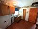 A functional kitchen with warm wood cabinets and laminate flooring, featuring a stainless steel double sink at 4335 River Rd, Columbus, IN 47203
