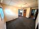 Carpeted living room with a chandelier and view to the kitchen with wood paneled walls at 4335 River Rd, Columbus, IN 47203