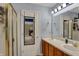 Well-lit bathroom featuring double sinks with wood cabinets and a large mirror over the vanity at 4511 Hunt Master Ct, Indianapolis, IN 46268