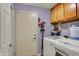 Functional laundry room featuring a washer, dryer, storage cabinets, and access to the outside at 4511 Hunt Master Ct, Indianapolis, IN 46268