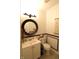 Elegant half bathroom with a decorative round mirror and stylish shell decor at 5266 Hickory Lake Dr, Indianapolis, IN 46235