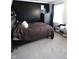 A modern bedroom featuring a dark accent wall, wooden bed frame, and neutral tones for a relaxing ambiance at 5266 Hickory Lake Dr, Indianapolis, IN 46235