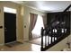 Bright foyer featuring tiled floor and staircase, adjacent to a carpeted living space with sunlit windows at 5266 Hickory Lake Dr, Indianapolis, IN 46235