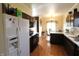 Modern kitchen with dark cabinets, white fridge, and an adjacent dining area with hardwood floors at 5266 Hickory Lake Dr, Indianapolis, IN 46235