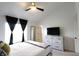 Light-filled main bedroom featuring a vaulted ceiling, ceiling fan, and modern white dresser at 5266 Hickory Lake Dr, Indianapolis, IN 46235