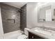 Well-lit bathroom with granite vanity, built-in shower niche and gray tiled walls at 5467 Winterhazel Dr, Indianapolis, IN 46254