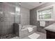 Gray tiled bathroom with separate shower and tub, plus a granite vanity at 5467 Winterhazel Dr, Indianapolis, IN 46254