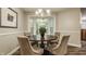 Cozy dining area with a round wooden table, four upholstered chairs, a chandelier, and bay window at 5467 Winterhazel Dr, Indianapolis, IN 46254