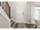 Inviting entryway with a white front door, wooden staircase, and light gray walls with hardwood floors at 5467 Winterhazel Dr, Indianapolis, IN 46254