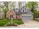 Charming home featuring a brick facade, a gray roof, an attached garage and a well-manicured front lawn at 5467 Winterhazel Dr, Indianapolis, IN 46254