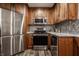 Modern kitchen features stainless steel appliances, wood cabinets, and marble countertops at 5467 Winterhazel Dr, Indianapolis, IN 46254