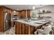 Kitchen features stainless steel appliances, wood cabinets, and large countertops with breakfast bar at 5467 Winterhazel Dr, Indianapolis, IN 46254
