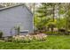 Landscaped backyard with flower beds featuring tulips and mature trees at 5467 Winterhazel Dr, Indianapolis, IN 46254