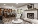Open-concept living area with a fireplace, bar seating and stainless steel appliances in the background at 5467 Winterhazel Dr, Indianapolis, IN 46254