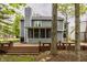 Back of the two-story home featuring a large wooden deck, a screened-in porch, and lush green landscaping at 5467 Winterhazel Dr, Indianapolis, IN 46254