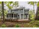 Exterior view showcasing a two-story home with a screened-in porch, wooden deck and well-landscaped backyard at 5467 Winterhazel Dr, Indianapolis, IN 46254