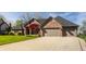 Beautiful brick home featuring a well-kept lawn, brick driveway, and an attached two-car garage at 5872 Lake Kessler Ct, Indianapolis, IN 46226