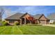 Lovely brick home boasting a lush lawn, brick driveway, and convenient two-car garage at 5872 Lake Kessler Ct, Indianapolis, IN 46226