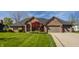 Charming brick home with manicured lawn, brick driveway, and two-car garage at 5872 Lake Kessler Ct, Indianapolis, IN 46226