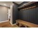 Hallway area with dark blue accent wall, bench, hooks and wood floors at 5872 Lake Kessler Ct, Indianapolis, IN 46226