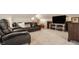 A cozy living room with a large TV, comfortable seating, and a carpeted floor at 5872 Lake Kessler Ct, Indianapolis, IN 46226