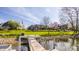 Breathtaking view of the home from the dock, surrounded by trees, lush landscaping, and inviting exterior at 5872 Lake Kessler Ct, Indianapolis, IN 46226