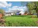Picturesque backyard featuring a green lawn, wooden fence, swing, and multiple sheds at 600 Alexandria Pike, Anderson, IN 46012
