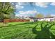 Expansive backyard with lush lawn, mature trees, a wooden fence and storage shed at 600 Alexandria Pike, Anderson, IN 46012