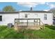 View of the house's back facade featuring a wooden deck and a well maintained lawn at 600 Alexandria Pike, Anderson, IN 46012
