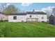 View of the house and the backyard featuring a wooden deck with access to the house at 600 Alexandria Pike, Anderson, IN 46012