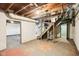 Unfinished basement with exposed ceiling, stairs, and open space at 600 Alexandria Pike, Anderson, IN 46012