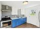Well-equipped kitchen featuring stainless steel appliances, white cabinets, and blue lower cabinets at 600 Alexandria Pike, Anderson, IN 46012