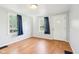 Bright living room with hardwood floors, blue curtains, and a welcoming front door at 600 Alexandria Pike, Anderson, IN 46012