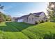 Well-maintained backyard with a spacious lawn and a charming exterior view of the home at 6017 Riva Ridge Dr, Indianapolis, IN 46237