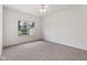 A well-lit bedroom featuring a large window, neutral carpet, and white walls, creating a serene atmosphere at 6017 Riva Ridge Dr, Indianapolis, IN 46237