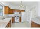 Eat-in kitchen with wooden cabinets, white appliances, and natural light at 6017 Riva Ridge Dr, Indianapolis, IN 46237